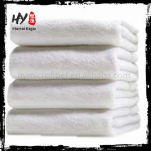 Las nuevas sábanas blancas de toalla de baño, toalla comprimida de aerolínea de hotel, toalla mongram de algodón